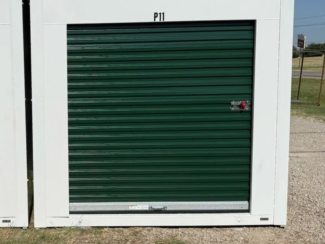 Outdoor drive-up storage container with green roll-up door at Lifetime